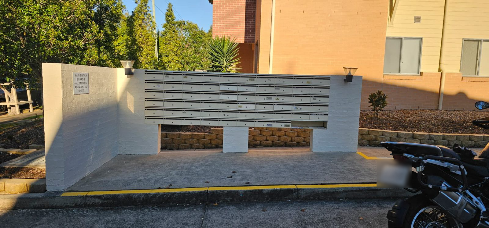 Painted brick letterbox wall at the entry to a unit complex